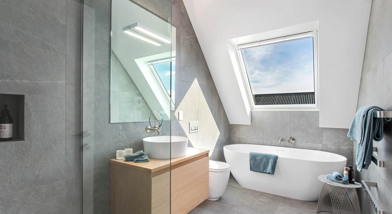 <img alt="Bathroom with freestanding bath, skylight and grey tiled walls, a calm and considered finish with natural light from above." src="/images/d/o/n/-/r/don-roy-site-architecture-moncks-bay-bathroom-b52327d1.webp?description" width="2560" height="1708" />