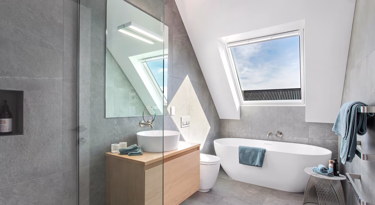 <img alt="Bathroom with freestanding bath, skylight and grey tiled walls, a calm and considered finish with natural light from above." src="/images/d/o/n/-/r/don-roy-site-architecture-moncks-bay-bathroom-f5e248ed.webp" width="2560" height="1708" />