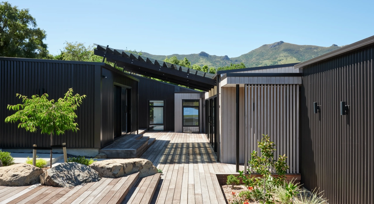 <img alt="Northern courtyard at Akaroa Pentref. Sheltered outdoor space between buildings with timber decking, Site Architecture." src="/images/n/o/r/t/h/northern-courtyard-akaroa-pentref-site-architecture-srp-765e82f1.webp?description" width="4000" height="3000" />