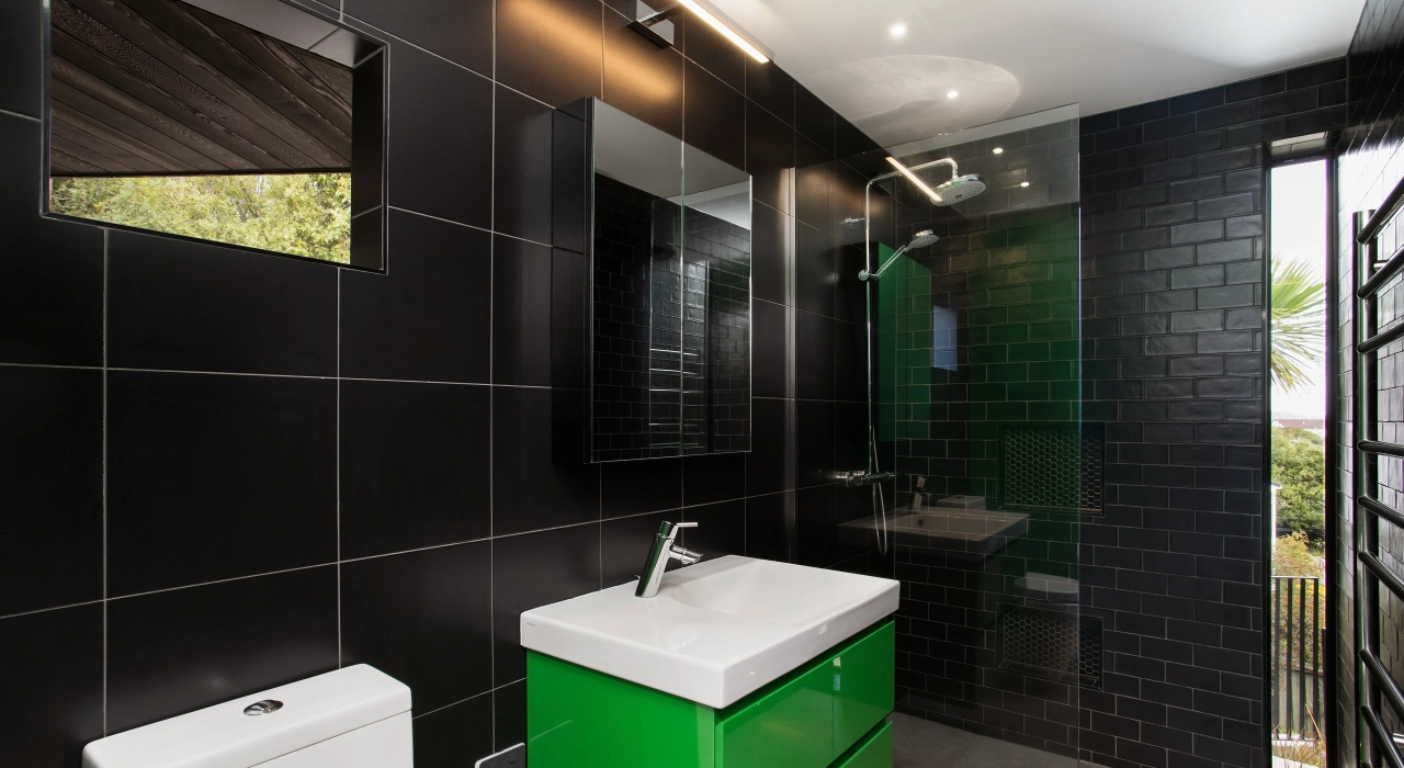 <img alt="Dark tiled bathroom with a green vanity and black fixtures, an unexpected burst of colour within the home." src="/images/s/i/t/e/-/site-arch-clementine-st-andrews-hill-bathroom-30d3915a.webp?description" width="6248" height="4163" />