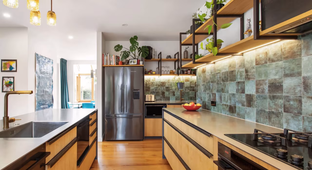 Renovated kitchen with open timber shelving, teal subway tile splashback and warm pendant lighting, Grange renovation by Site Architecture.