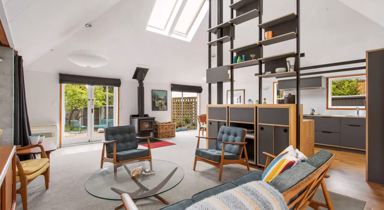 Living area with new timber and steel shelving system, mid-century furniture and skylight, Paulus alteration by Site Architecture.