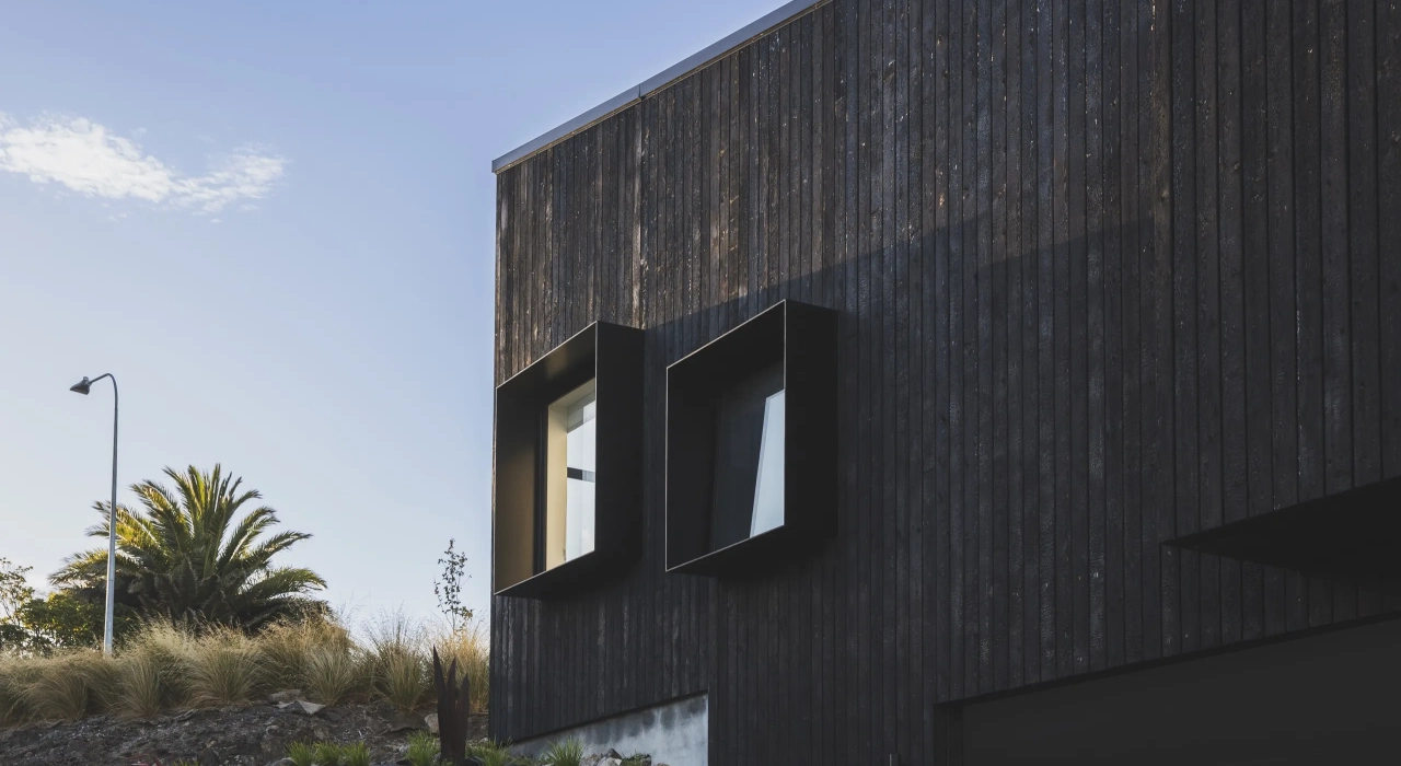 <img alt="Charred larch cladding and angular roofline of Drayton house against a clear sky." src="/images/s/i/t/e/-/site-architecture-drayton-drive4-75c45573.webp?description" width="2560" height="1706" />