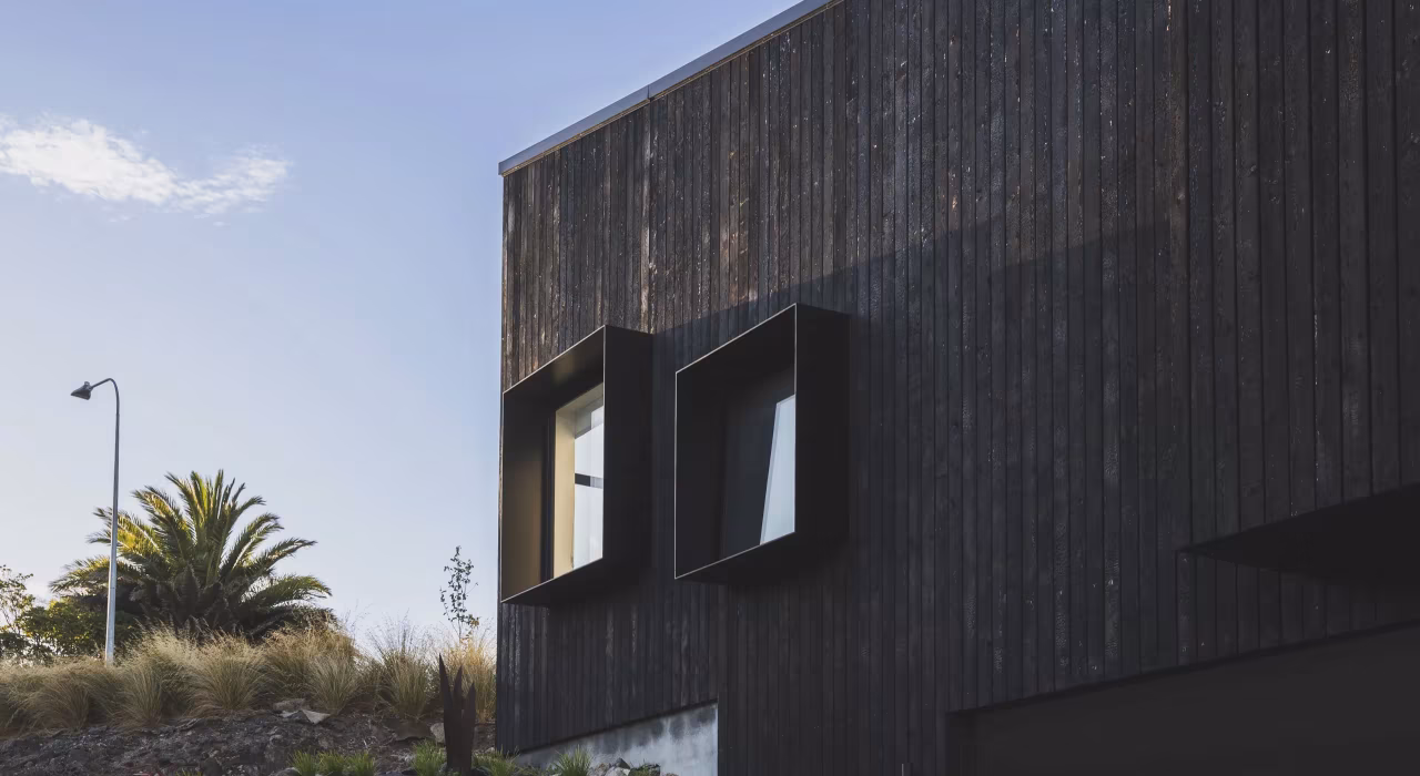 <img alt="Charred larch cladding and angular roofline of Drayton house against a clear sky." src="/images/s/i/t/e/-/site-architecture-drayton-drive4-e8ff7146.webp" width="2560" height="1706" />