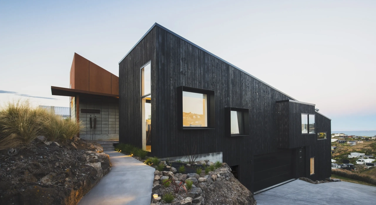 <img alt="Drayton house nestled into the rocky hillside at Mt Pleasant, charred larch volumes stepping with the natural contours." src="/images/s/i/t/e/-/site-architecture-drayton-drive9-07eb4c1c.webp?description" width="2560" height="1706" />