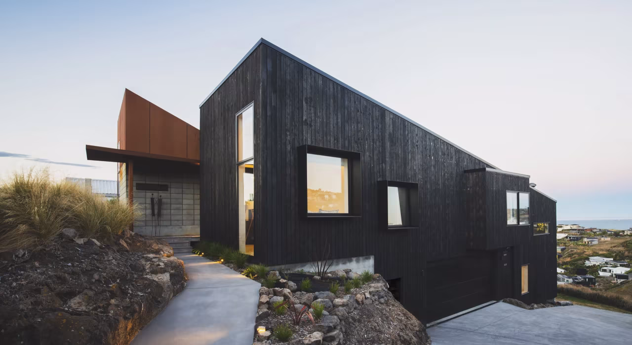 <img alt="Drayton house nestled into the rocky hillside at Mt Pleasant, charred larch volumes stepping with the natural contours." src="/images/s/i/t/e/-/site-architecture-drayton-drive9-fc001f64.webp" width="2560" height="1706" />