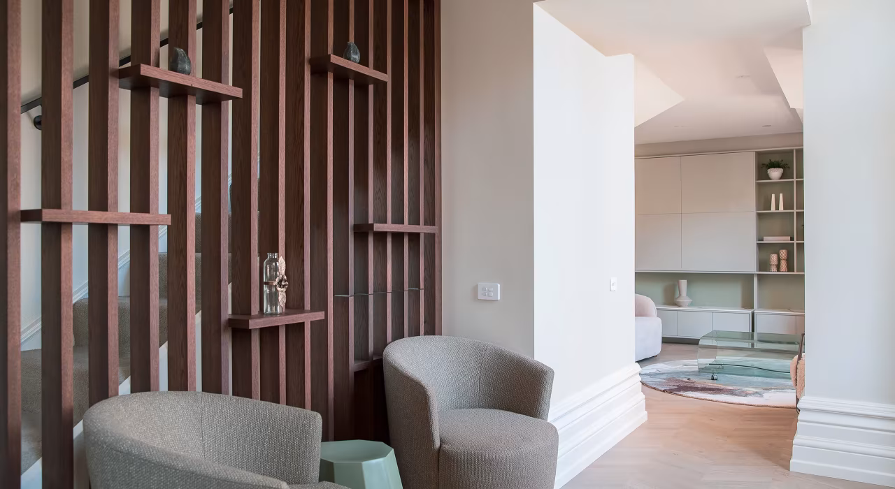 Living area of Suite 17 with timber slat wall detail, built-in shelving and soft natural light, Old Government Building Christchurch.