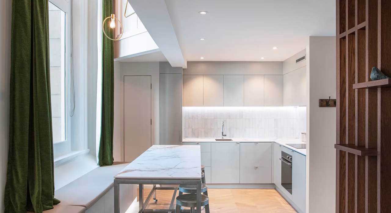 <img alt="Contemporary kitchen with sage green cabinetry, pendant lighting and dark curtains framing the city beyond." src="/images/s/i/t/e/-/site-architecture-suite-17-ogb-interior-architecture6-e0b5d395.webp" width="2560" height="1707" />