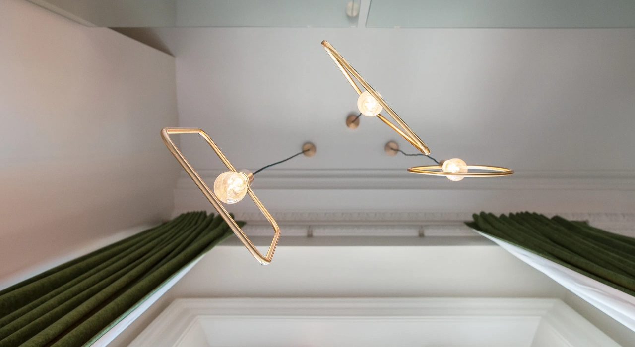 <img alt="Sculptural brass pendant light against a soft grey ceiling, a refined decorative detail within the apartment." src="/images/s/i/t/e/-/site-architecture-suite-17-ogb-interior-architecture7-c789449a.webp?description" width="2560" height="1707" />