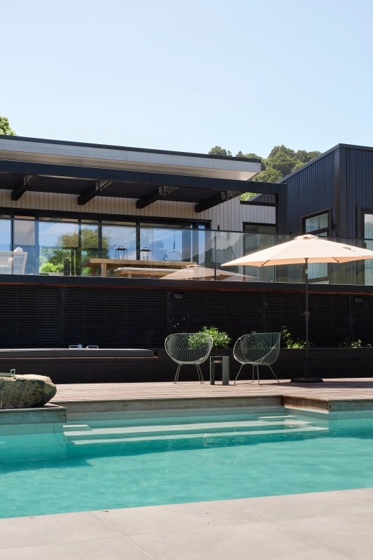 <img alt="South-west elevation of Akaroa Pentref. Dark coloursteel cladding, pool and outdoor furniture. Coastal residential architecture." src="/images/s/o/u/t/h/south-west-elevation-akaroa-pentref-site-architecture-srp-fd047f3c.webp?description" width="3000" height="4000" />